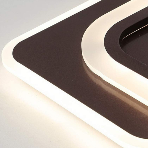 A close-up of the Plafonnier LED nordique avec capteur de mouvement PIR, a modern wall light for salon, chambre ou entrée, showing geometric black and white rectangles softly outlined by a white glow.